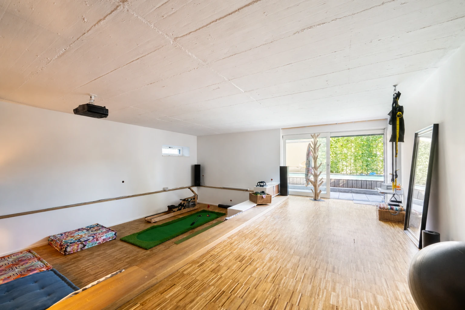 Großzügiger Sportbereich mit Terrasse und Sichtbetondecke